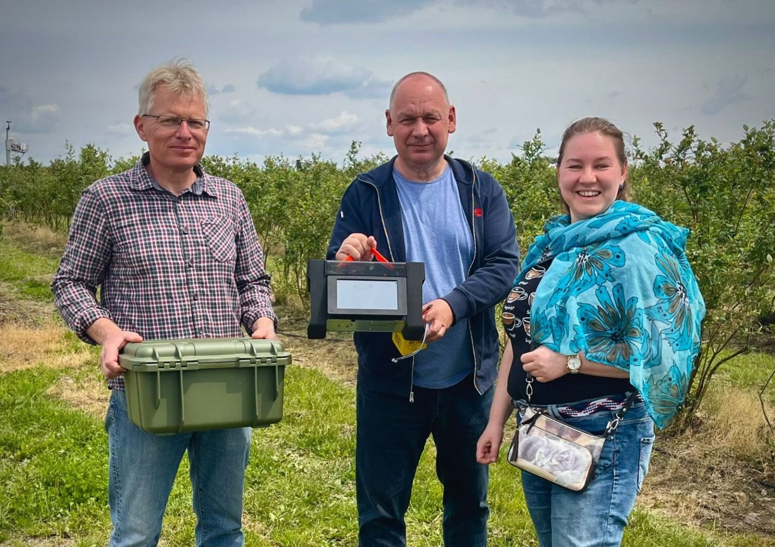 Team demonstrating the SMAGRY portable soil analyzer and case, ready for field testing